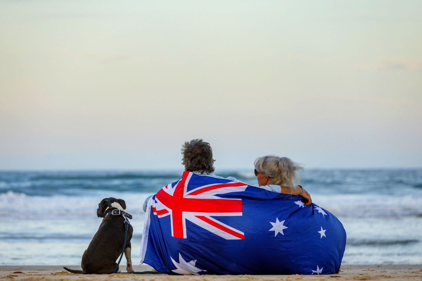 Couple wrapped in Australian flag on beach